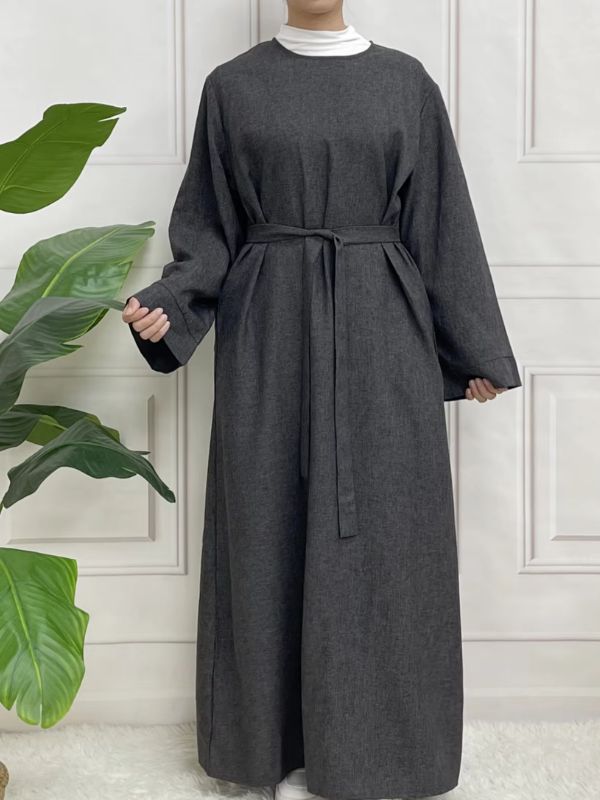 Une femme porte une abaya en satin gris