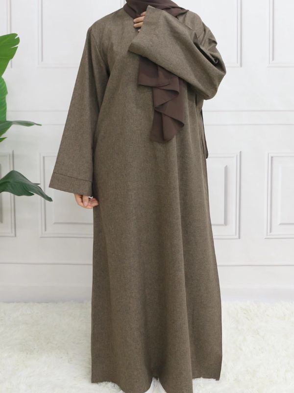 Une femme porte son abaya marron foncé