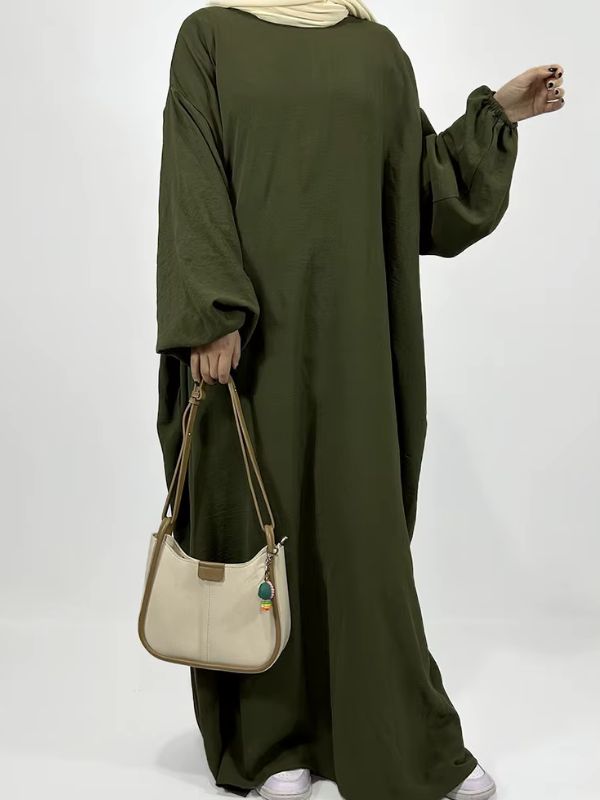 Une femme porte une abaya verte