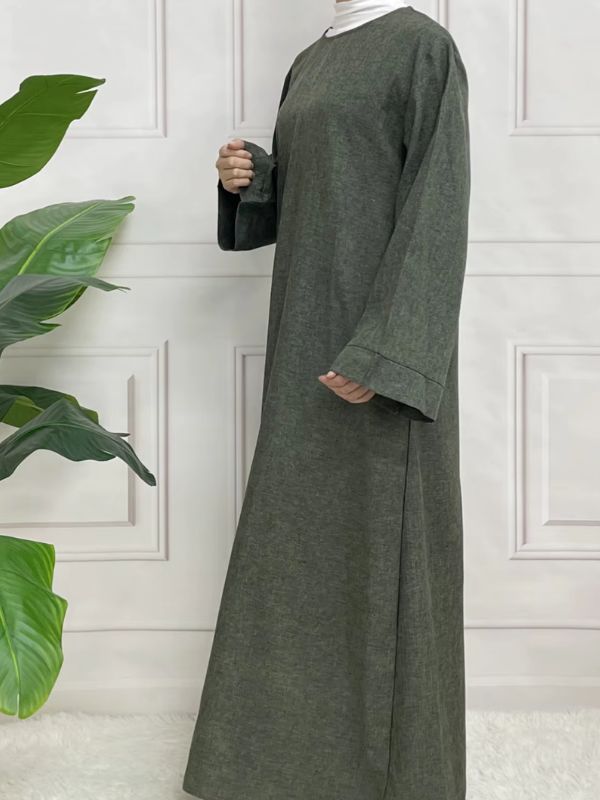 Une femme porte une abaya en satin vert kaki