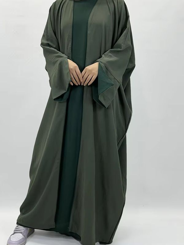 Une femme portant une abaya satin verte deux pièces kimono