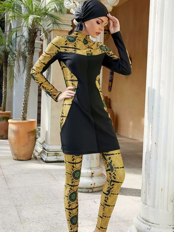 Une femme en burkini noir et doré, posant devant des colonnes