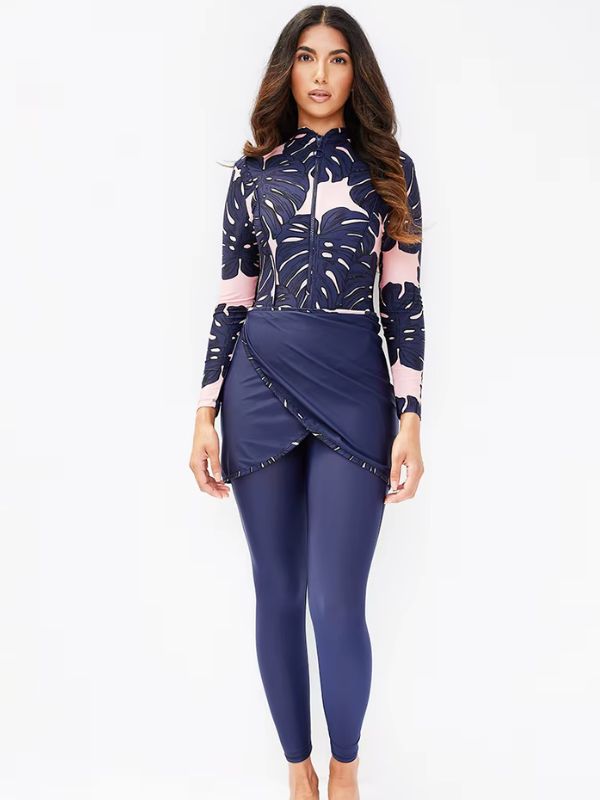 Une femme en burkini bleu pose avec un arrière-plan gris