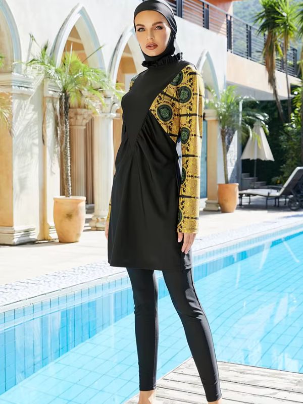 Une femme portant un burkini noir avec des manches ornées de motifs dorés