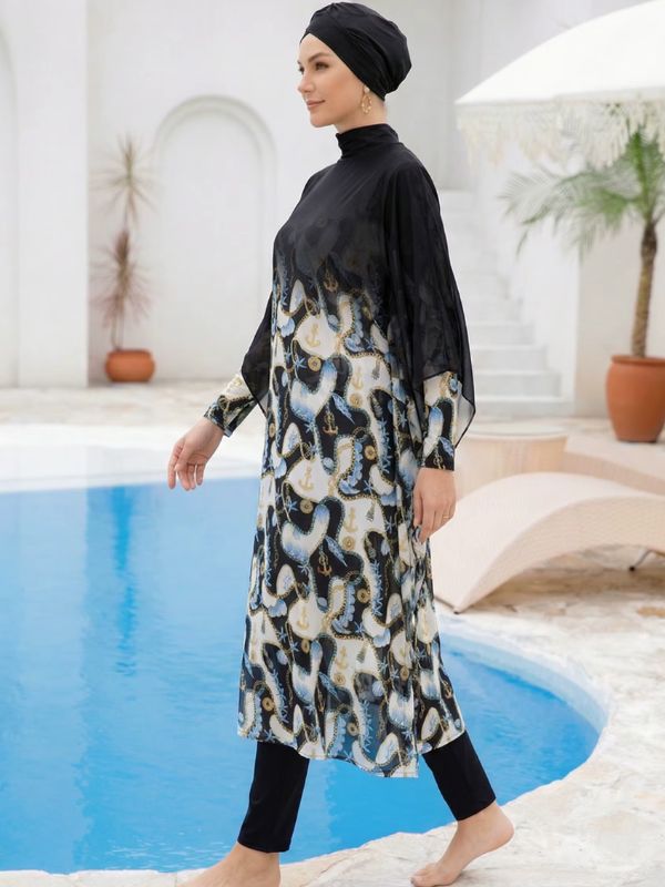 Burkini hijab noir vu de profil en marchant, voile des manches cape et bas de tunique à ancres crème