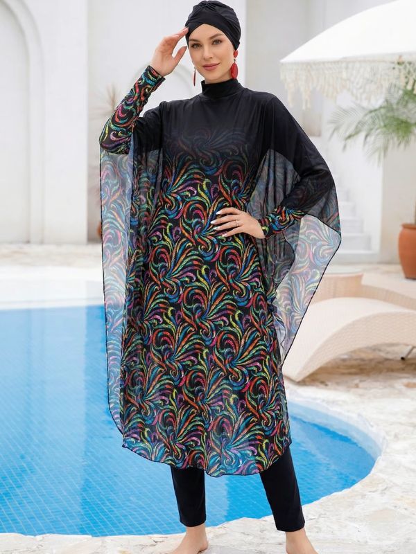 Burkini hijab noir à volutes multicolores, manches cape en voile et bonnet-turban noir, vue de face au bord d'une piscine