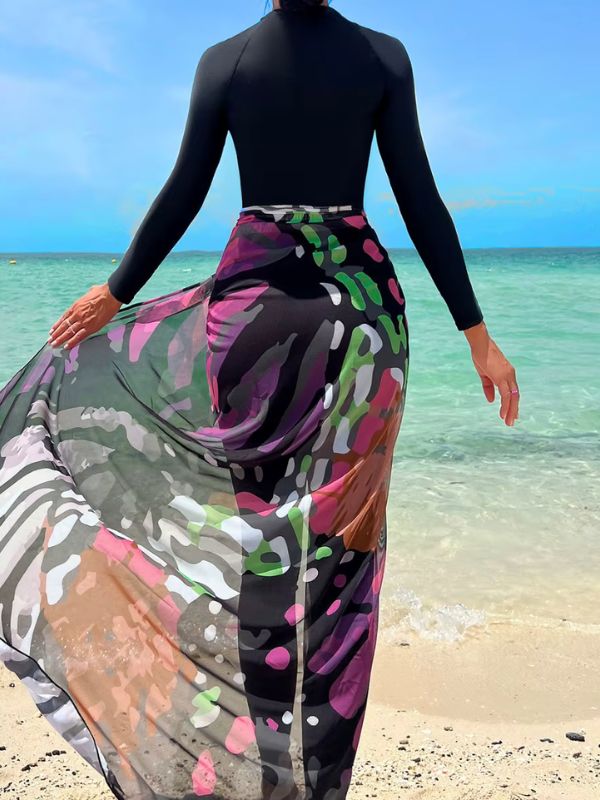 Femme en burkini noir avec un paréo coloré, de dos sur la plage