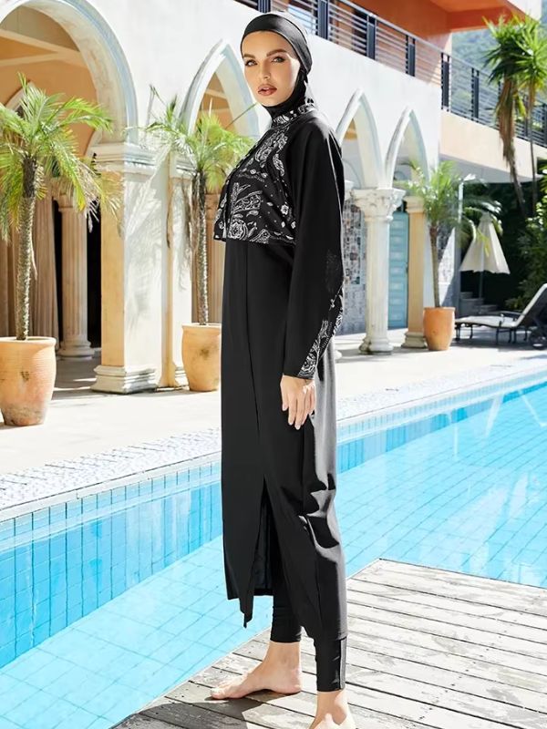 Une femme porte un magnifique burkini noir devant une sublime piscine