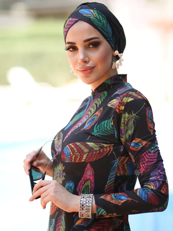 Une femme porte un burkini 3 pièces à motifs plumes