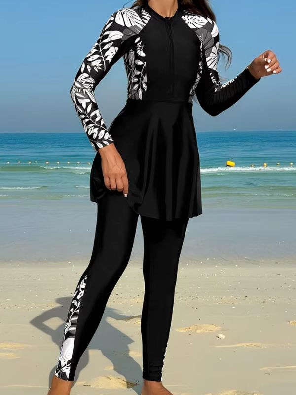 Burkini sport noir à feuillages noirs et blancs, en marche sur la plage, bande imprimée sur la jambe du pantalon