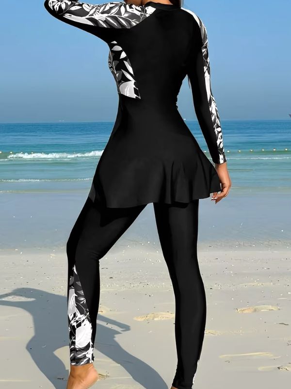 Dos du burkini sport noir à feuillages noirs et blancs, bande imprimée sur la jambe du pantalon, vue de trois quarts