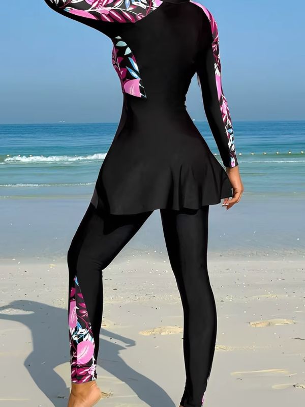 Dos du burkini sport noir à feuillages roses, bande imprimée sur la jambe du pantalon, vue de trois quarts