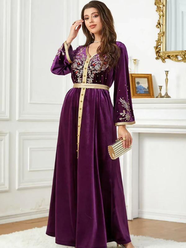 Une femme porte un caftan en velours améthyste avec des manches longues