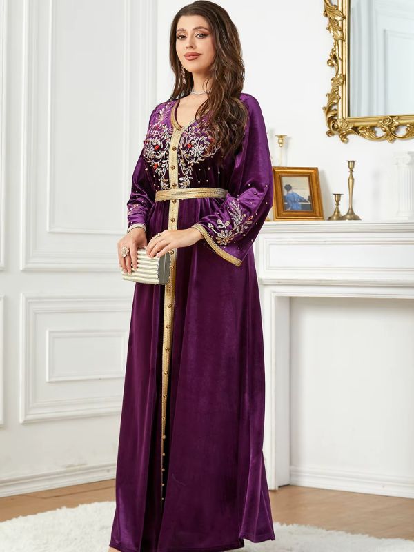 Une femme vêtue d’un caftan améthyste avec une ceinture dorée