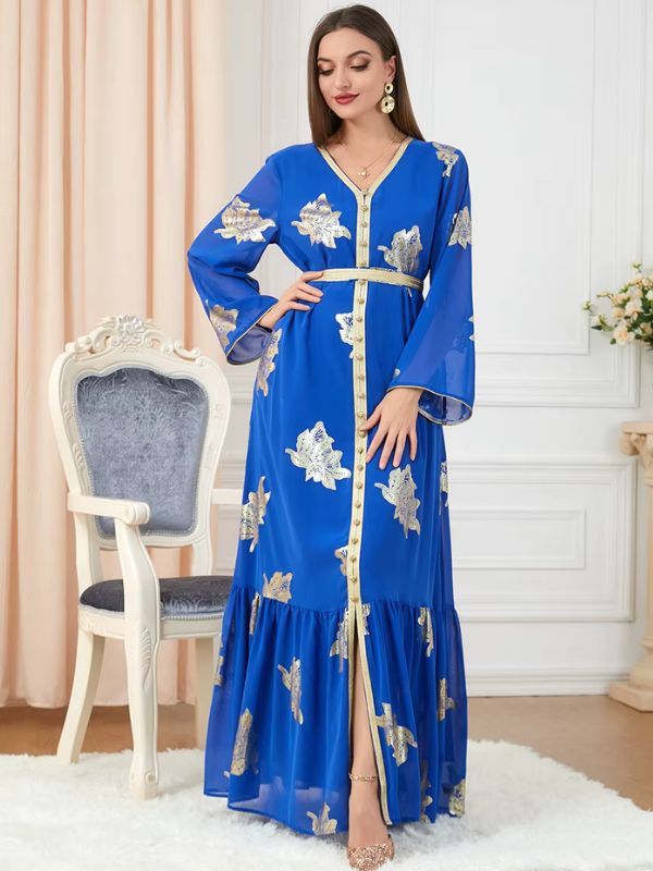 Une femme debout dans un décor raffiné, portant un caftan bleu royal