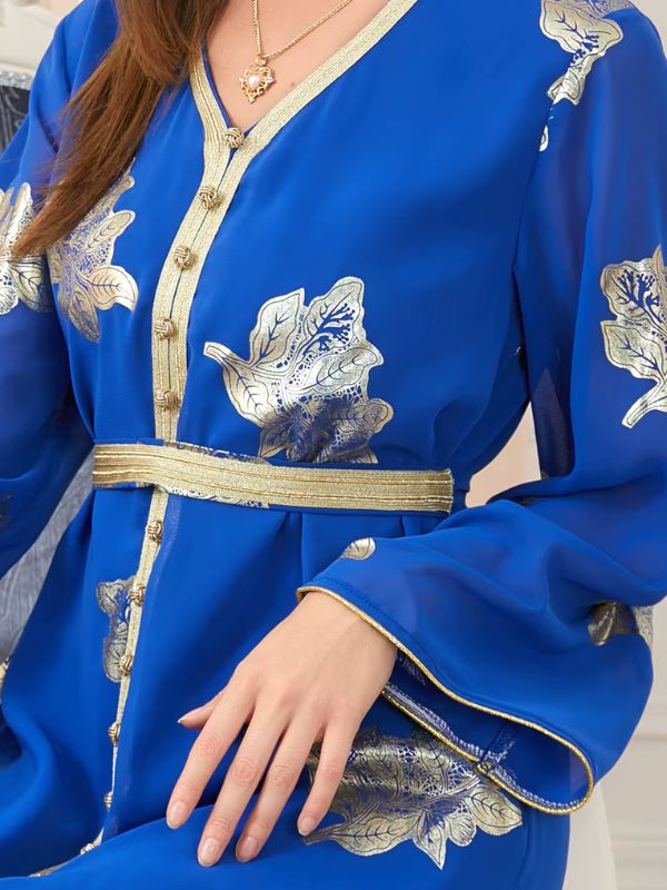 Zoom sur les détails du caftan bleu royal, montrant des broderies dorées