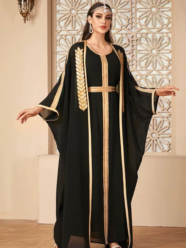 Femme portant un caftan noir orné de motifs dorés luxueux