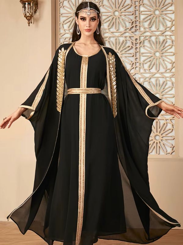 Femme posant avec un caftan noir manches amples et ornements dorés