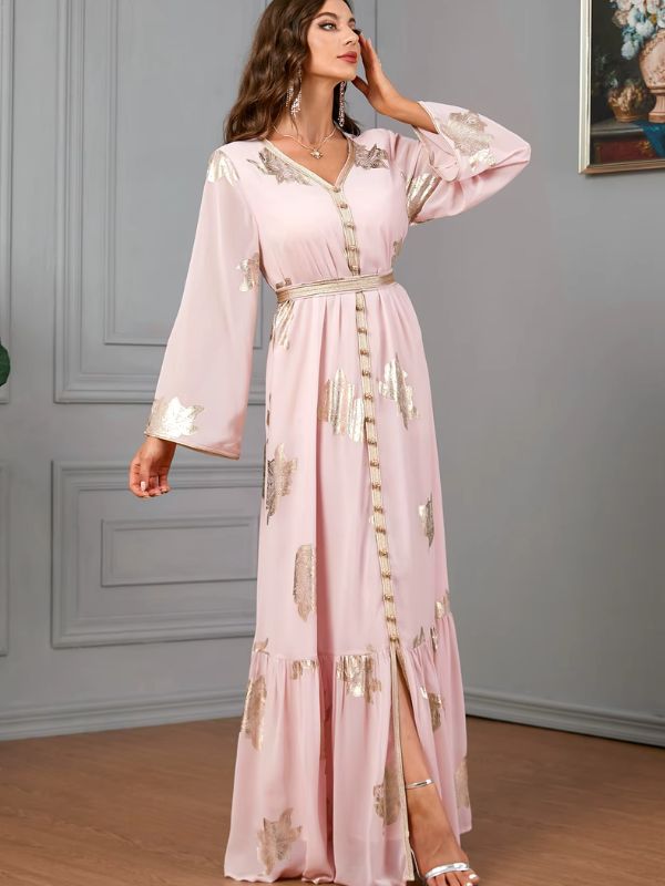 Une femme porte un caftan algérien rose perle, décoré de motifs dorés