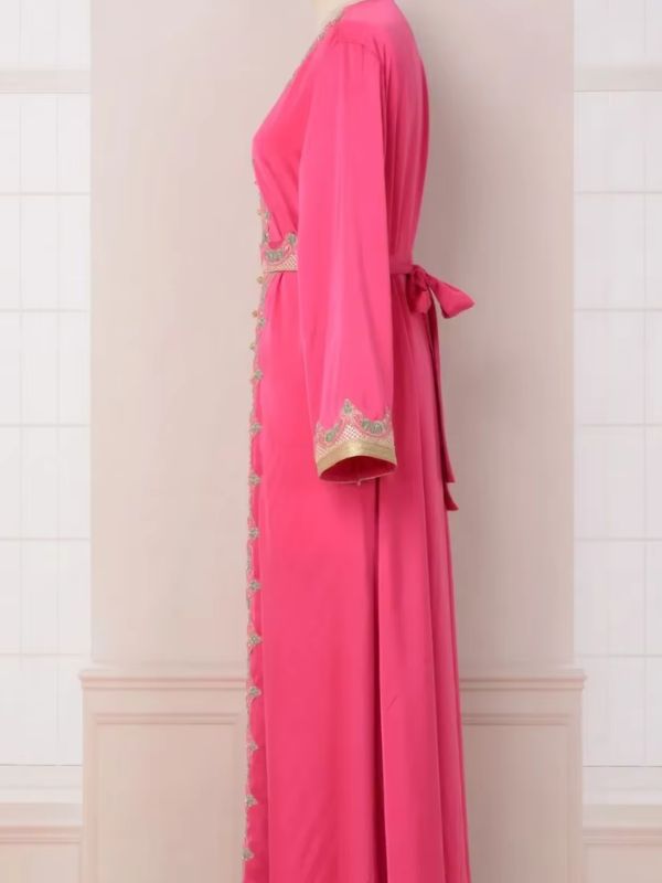 Un caftan rose à la coupe ample et fluide, embelli de broderies