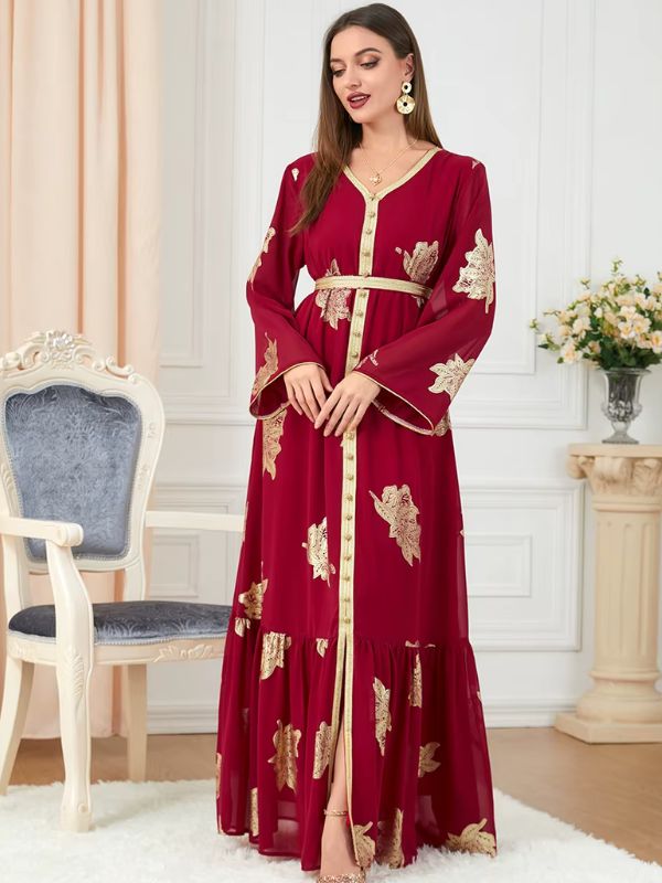 Une femme vêtue d&#39;un caftan rouge élégant avec broderies dorées