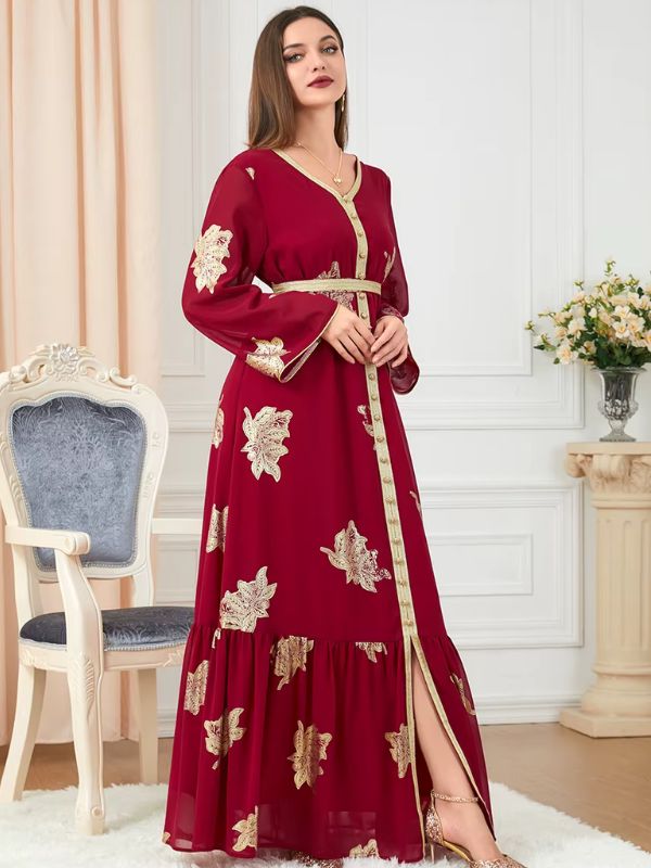 Une femme debout dans un caftan rouge et doré