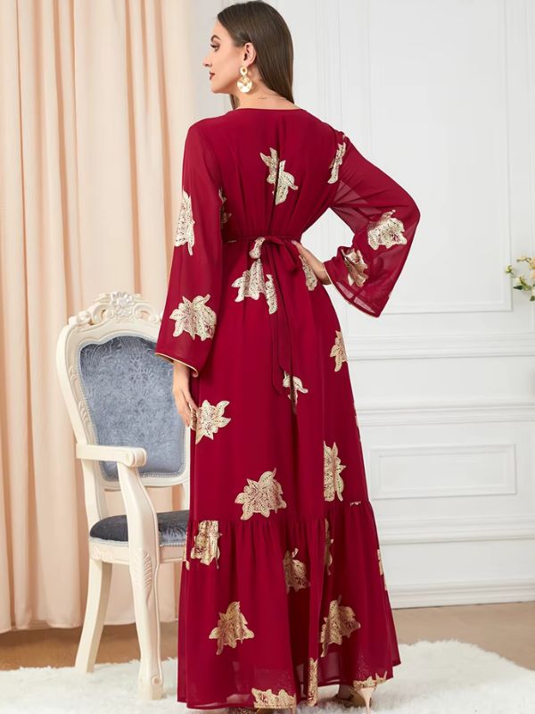 Vue arrière d&#39;une femme portant un caftan rouge orné de motifs dorés