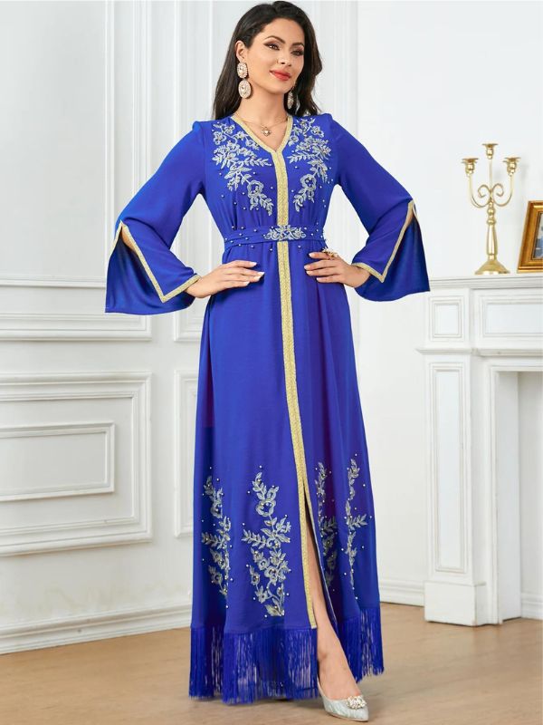 Une femme porte un caftan bleu royal avec des broderies argentées