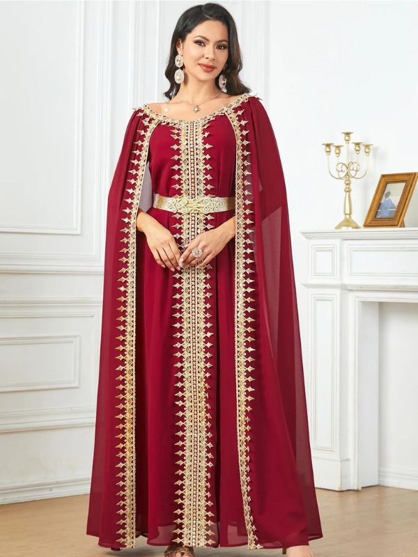 Femme qui porte un sublime caftan rouge rubis dans un intérieur royal