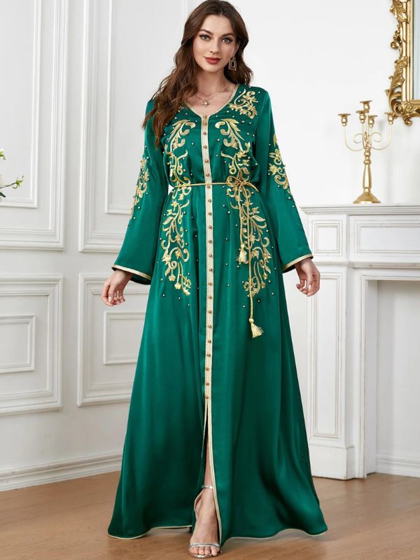 Femme qui porte un fabuleux caftan de luxe de couleur vert émeraude