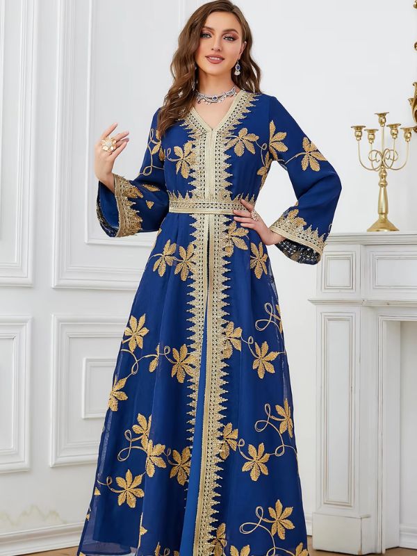 Une femme porte un caftan de couleur bleu avec des motifs très jolies en forme de fleurs