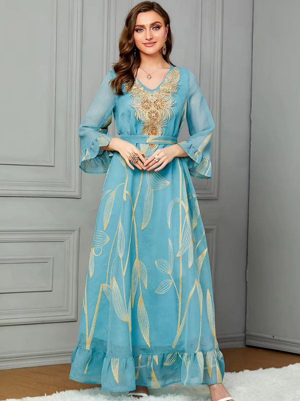 Une femme porte un caftan bleu ciel dans un magnifique appartement