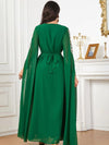 Vue de dos, une femme porte un caftan vert émeraude