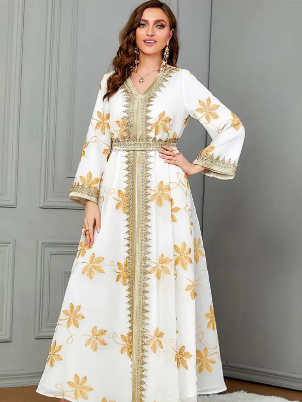 Vue de face d'une femme qui porte un caftan de mariage blanc aux motifs fleurs