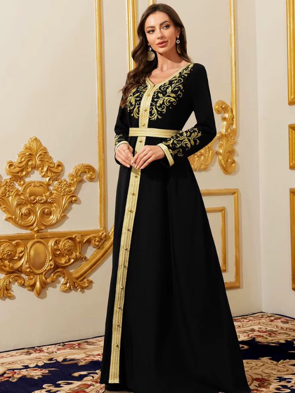 Femme debout portant un caftan marocain noir à broderies dorées 