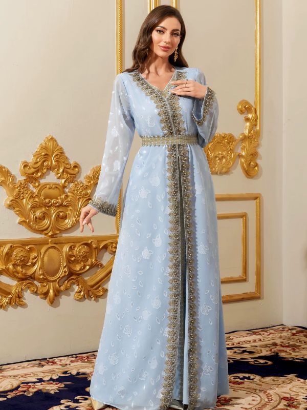Femme portant un caftan marocain bleu ciel aux riches broderies dorées et perlées