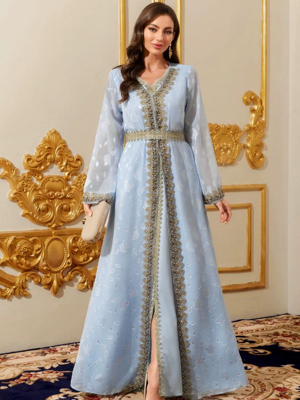 Femme portant un caftan marocain bleu ciel aux riches broderies dorées et perlées