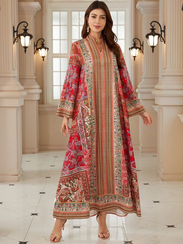 Caftan à motifs cachemire rouge et bordure brodée, porté avec bagues et bracelet dorés