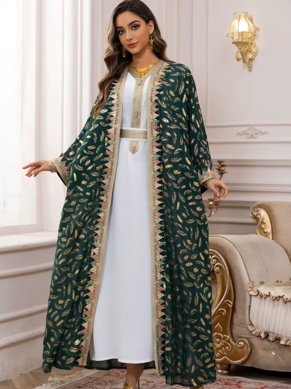 Une femme porte un caftan marocain vert émeraude aux broderies dorées