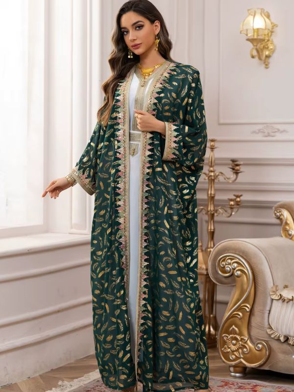 Une femme porte un caftan marocain vert émeraude aux broderies dorées