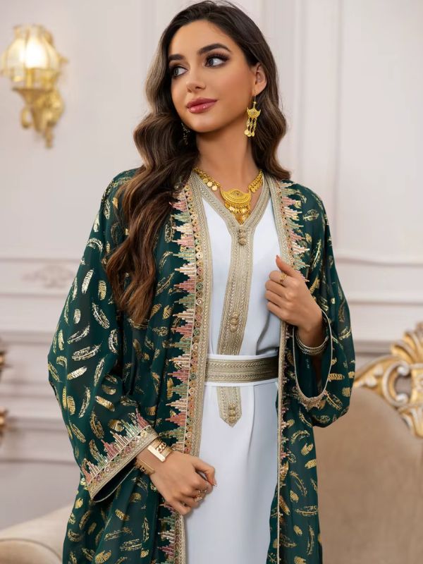 Femme debout près d’une fenêtre en caftan marocain vert foncé