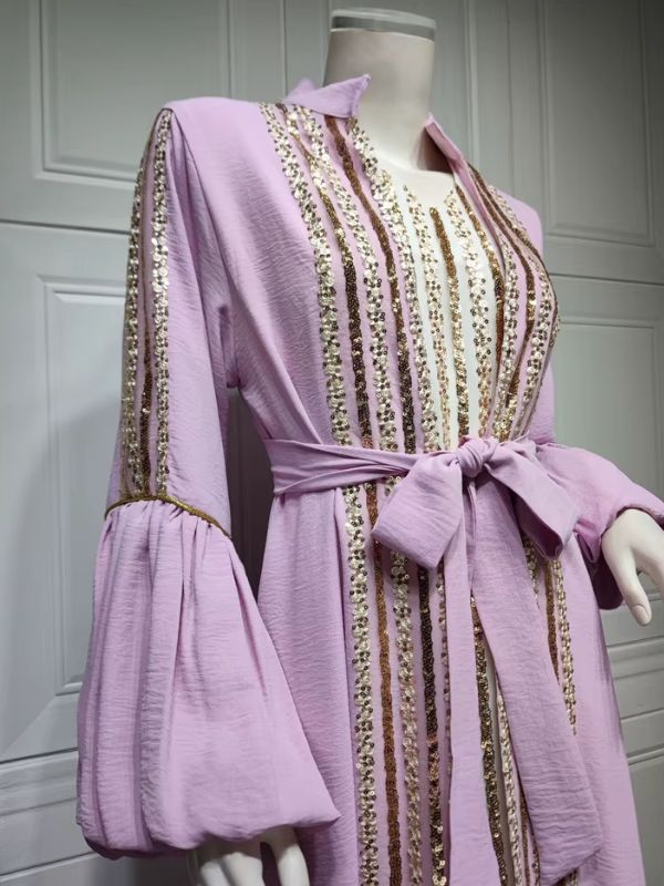 Vue de trois quarts d'un caftan lavande à manches ballon, bandes de sequins dorés et ceinture nouée.