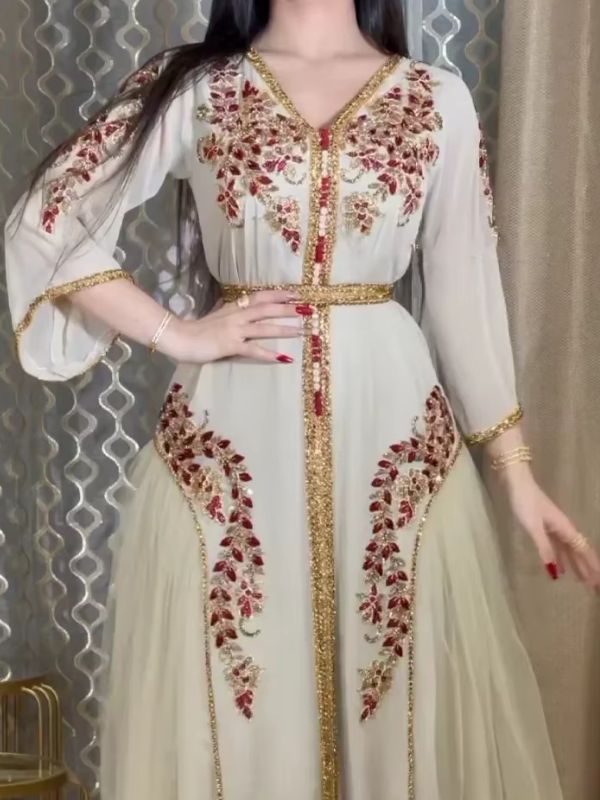 Une femme porte un caftan marocain ivoire à broderies florales sublime