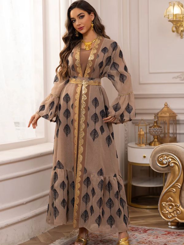 Une femme en caftan marocain beige doré avec détails feuillagés noirs