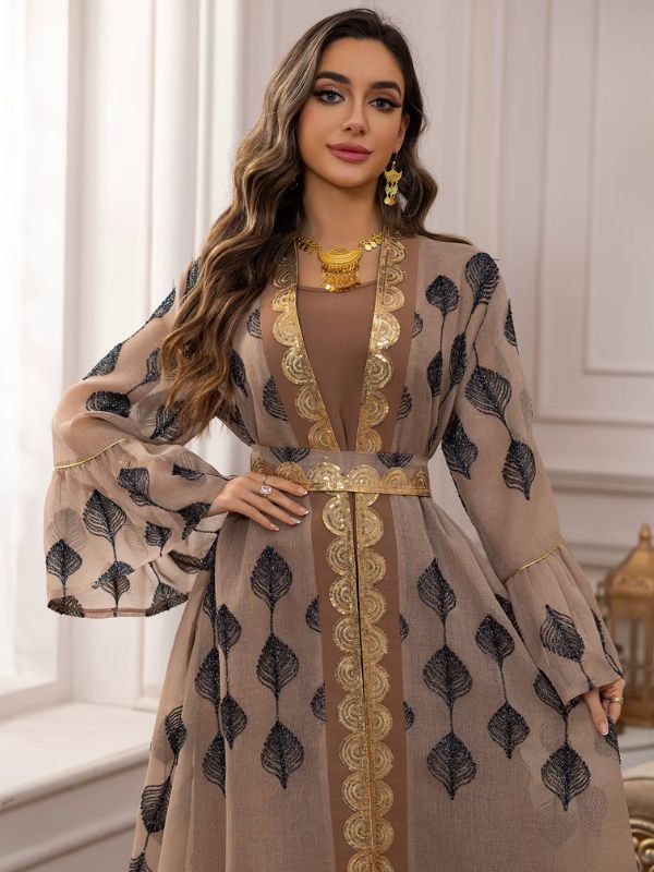 Une femme porte un caftan marocain élégant couleur sable décoré