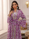 Une femme élégante pose près d’une fenêtre dans un caftan marocain violet