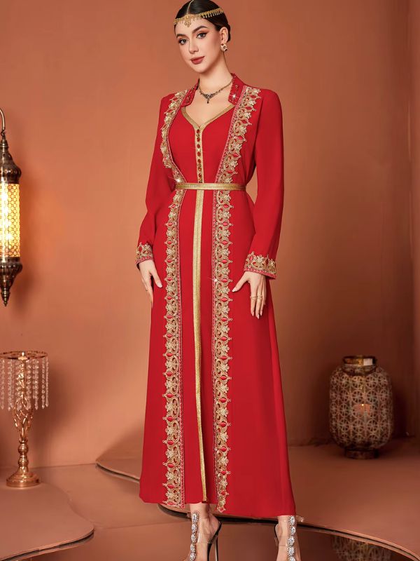 Femme portant un caftan marocain rouge à galon doré ajouré et col officier, bijou frontal doré, debout de face