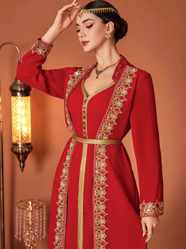 Femme en caftan marocain rouge et or, gros plan sur le galon ajouré serti de pierres rouges au niveau du buste