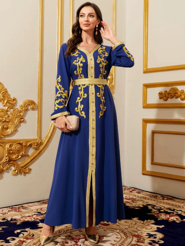 Femme portant un caftan marocain bleu royal brodé d'or, pochette scintillante à la main, dans un intérieur élégant