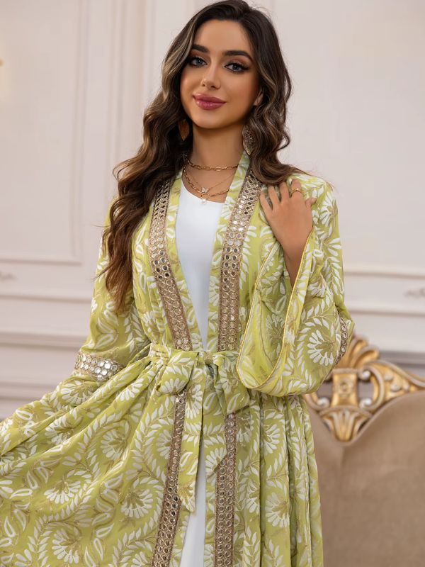 Une femme porte un caftan marocain vert clair à motifs floraux 